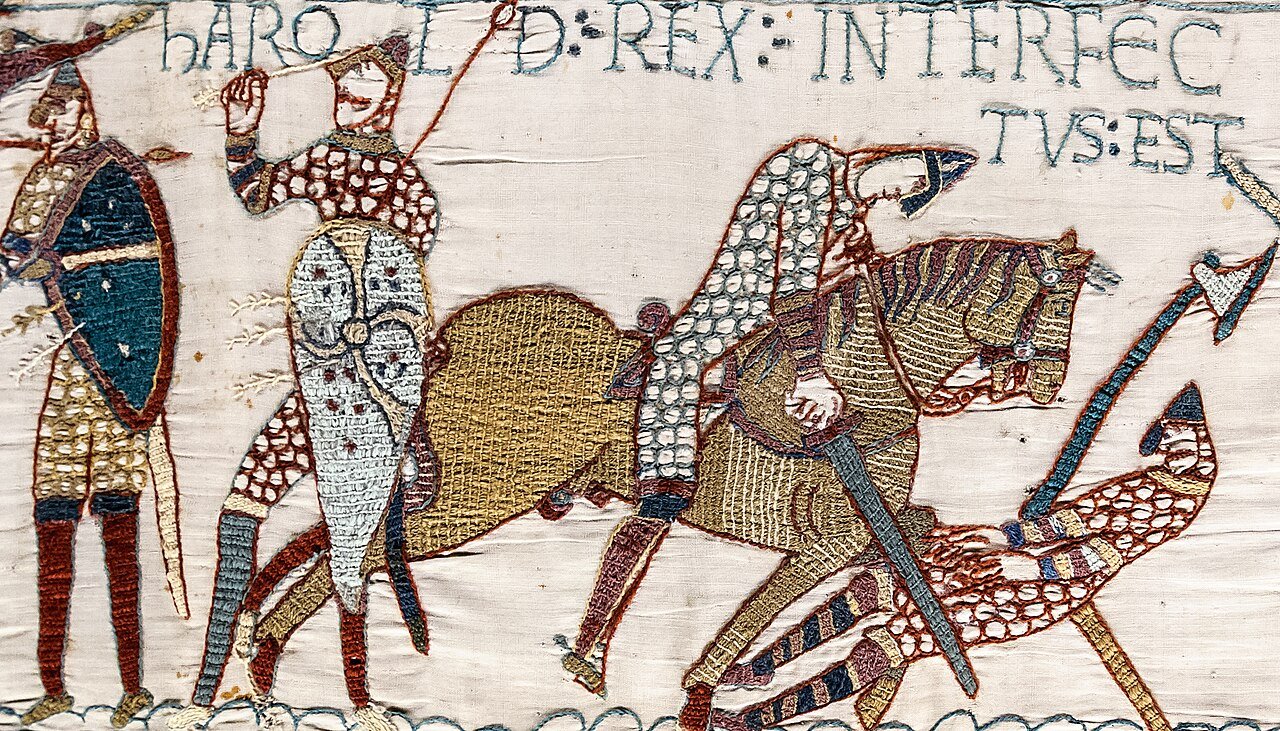 Scene 57 of the Bayeux Tapestry, where a soldier grips an arrow by his face beneath the words announcing Harold's death