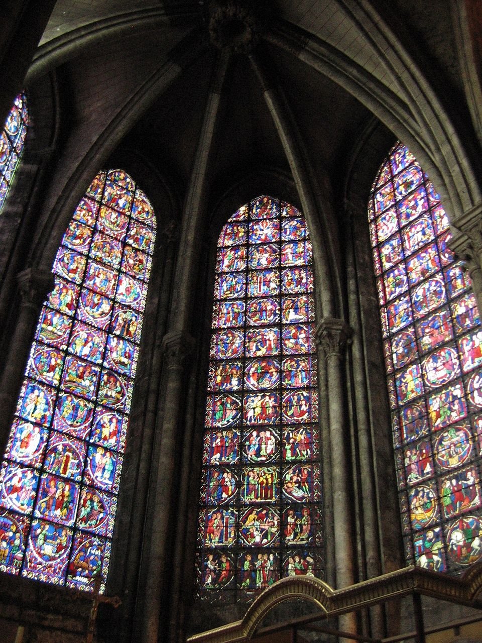 Medieval stained glass windows in the choir of Chartres Cathedral, glowing in deep blue and red